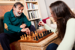 elderly man and caregiver playing chess